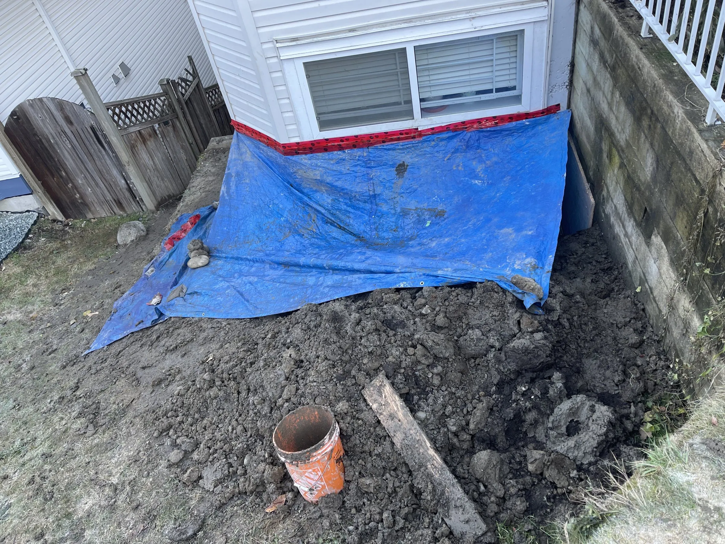 Before: Regraded area with drain rock outside a basement window