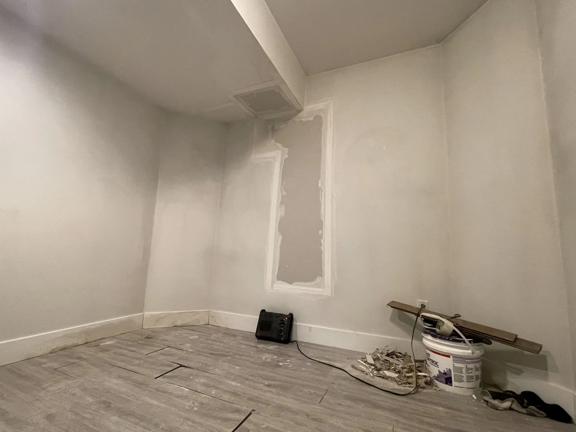 Basement room with drywall repairs and new baseboards