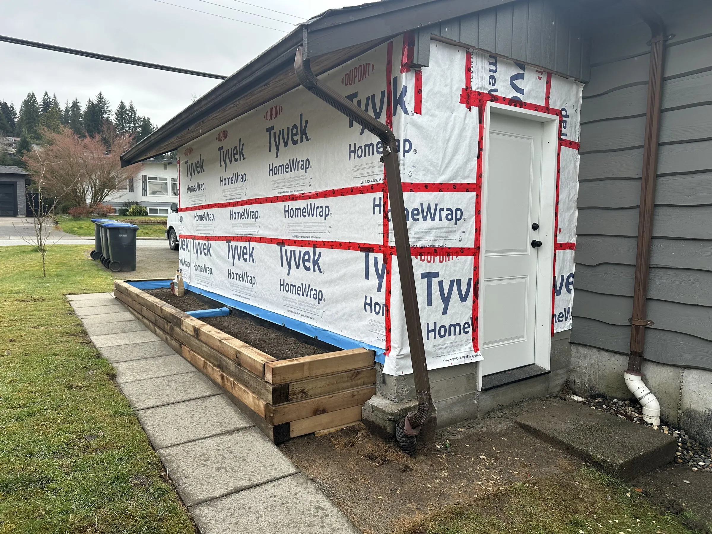 New side entry door, house wrap and planter boxes